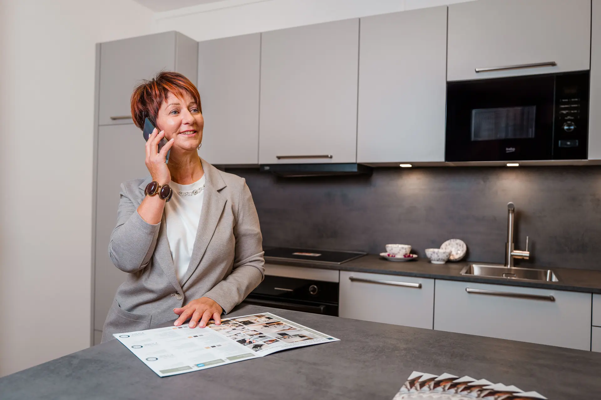 Frau lacht und telefoniert, im Hintergrund befindet sich das Urban Line Danküchen Model.